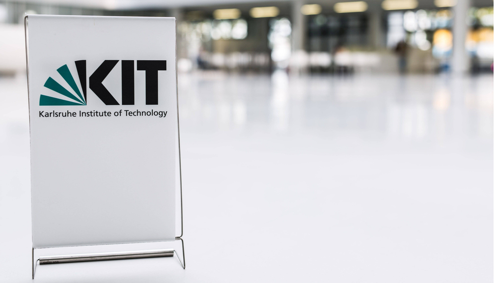 KIT Logo auf Tafel vor verschwommenem Hintergrund