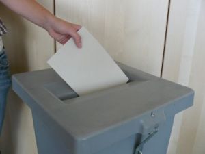 Welche Motive führen zur Stimmvergabe - eine Studie am KIT beleuchtet dieses Thema. Das Bild zeigt eine Person, die einen Stimmzettel in eine Wahlurne einwirft.