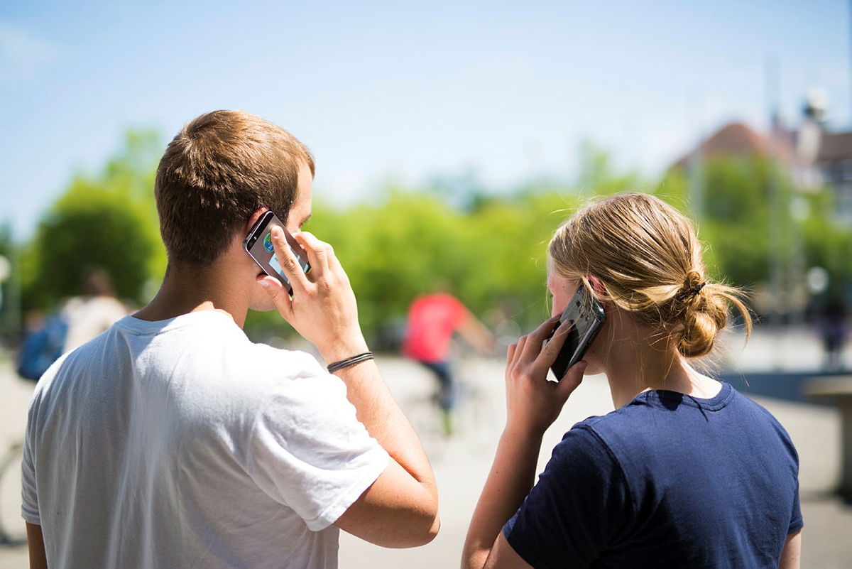 Zwei junge Menschen, die telefonieren
