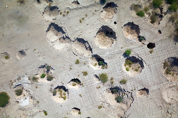 Erdfaelle1_k.jpg - Dieses Foto zeigt besonders tiefe Erdfälle, wie sie in alluvialen Sedimenten vorkommen. Einsturzlöcher treten immer häufiger auf und führen zum Verlust landwirtschaftlicher Anbauflächen sowie zur Zerstörung von Infrastruktur am Ostufer des Toten Meeres.Foto: Djamil Al-Halbouni & Eoghan Holohan, Helmholtz-Zentrum Potsdam 