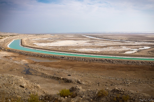 Kanal_k.jpg - Auf Höhe von Masada – einer jüdischen Festung aus dem 1. Jh. v. Chr. – teilt sich das Tote Meer in ein Nord- und ein Südbecken. Das Nordbecken ist größer und mit über 350 m deutlich tiefer als das nur vier bis sechs Meter tiefe Süd-becken. Die beiden Becken sind durch einen Kanal miteinander verbunden, über den Wasser nach Süden gepumpt wird. Ohne diesen Kanal wäre das Südbecken inzwischen ausgetrocknet. Als Nebenprodukt des industriellen Abbaus von Mineralen reichert sich Salz am Grund des Südbeckens an, wodurch es hier zu einem stetigen Anstieg des Seespiegels um etwa 20 cm pro Jahr kommt.Foto: Stefan Schmitt, Universität Heidelberg