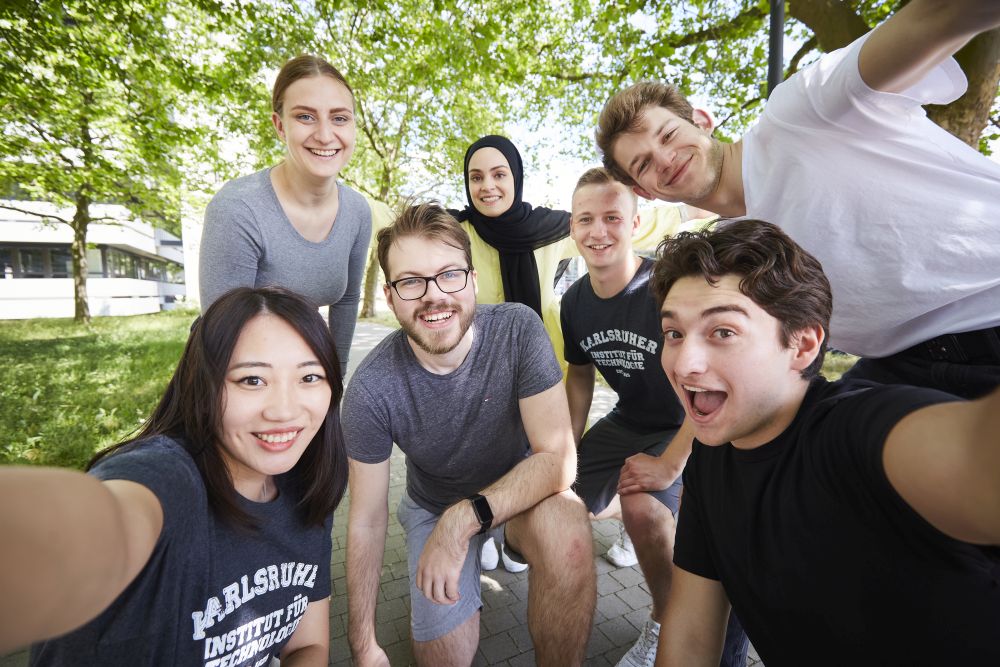 Gruppe junger Studierender macht Selfie am Campus Süd, alle schauen in Kamera
