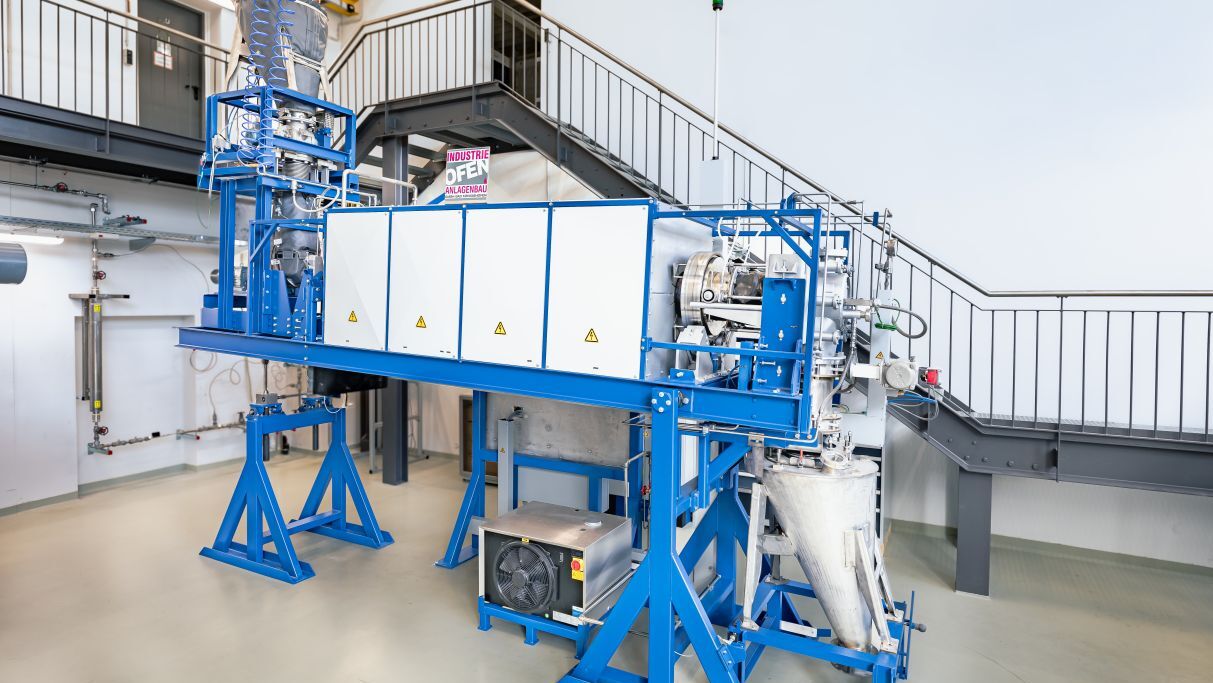 Helmut Reis, KIT Industrial machinery with blue metal framework and white panels in a facility.