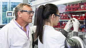 Professor Stefano Passerini and his colleague Hyein Moon assemble a sodium ion battery on a glove box. (Photo: Amadeus Bramsiepe, KIT)