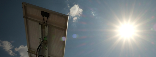 View from below onto a solar module and into radiant sunlight