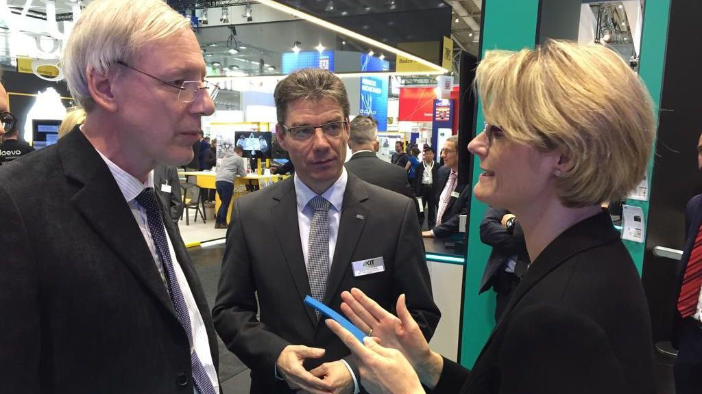 Thomas Schimmel (vorn), Michael Decker (hinten), und Bundesforschungsministerin Anja Karliczek (vorn) am Demonstrator einer bionischen Schiffbeschichtung