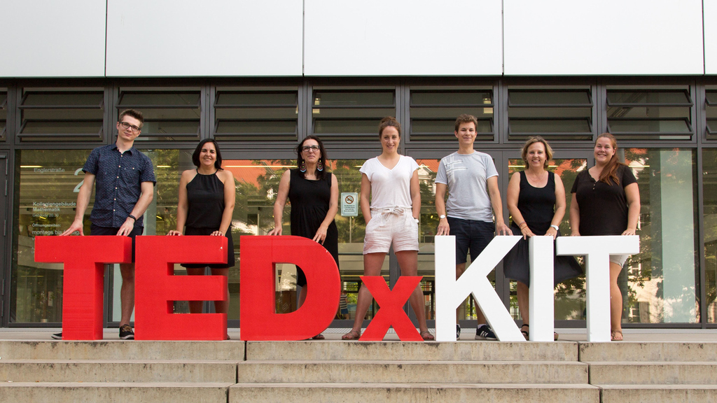 Auf einer Treppe hat sich das Team von TEDxKIT mit den Buchstaben aufgestellt