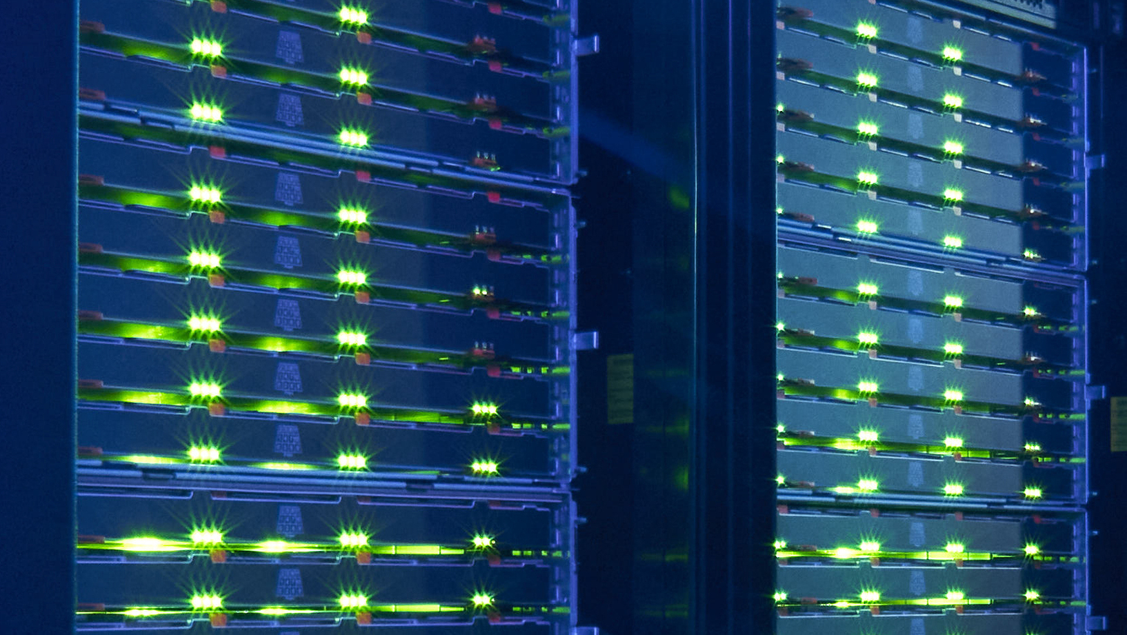 KIT Glowing green server lights in a data center rack.