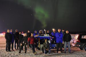 Jülicher und Karlsruher Forscher im nordschwedischen Kiruna mit dem GLORIA-Detektor in ihrer Mitte und einem Polarlicht über ihren Köpfen. (Foto: Erik Kretschmer/KIT)