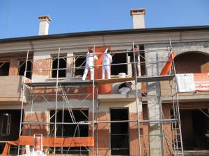 In langen Bahnen wird Erdbebenschutzgewebe auf Mauerwerk aufgebracht und dann verputzt. Im Ernstfall hält es Trümmer zusammen und Rettungswege frei. (Bild: M. Urban/KIT)