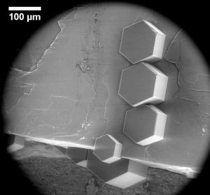 Eiskristalle auf einem Feldspatkristallit unter dem Elektronenmikroskop. Obwohl sie auf verschiedenen Ebenen des Feldspats wachsen, sind sie zueinander ausgerichtet. (Abbildung: Alexei Kiselev und Dagmar Gerthsen/KIT)