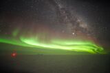 Polar light above the South Pole. The red point is the IceCube Laboratory. The neutrino experiment proper is installed several kilometers deep in the ice. (Photo: Kathrin Mallot, IceCube, NSF)