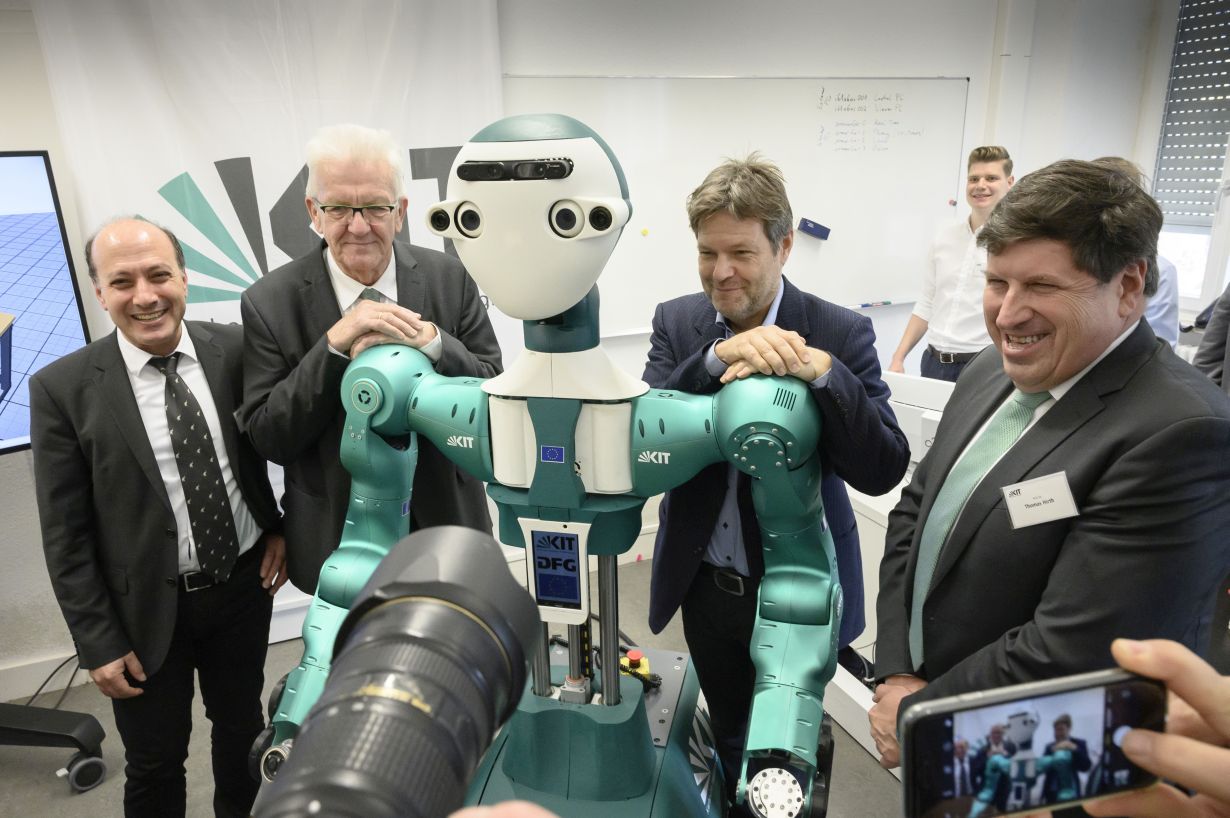 Meeting the smart robot ARMAR-6 at KIT: From left to right: Prof. Tamim Asfour, KIT, Minister-President Winfried Kretschmann, Federal Chairman of the Green Party, Dr. Robert Habeck, and Vice-President of KIT, Prof. Thomas Hirth. (Photo: Markus Breig, KIT)