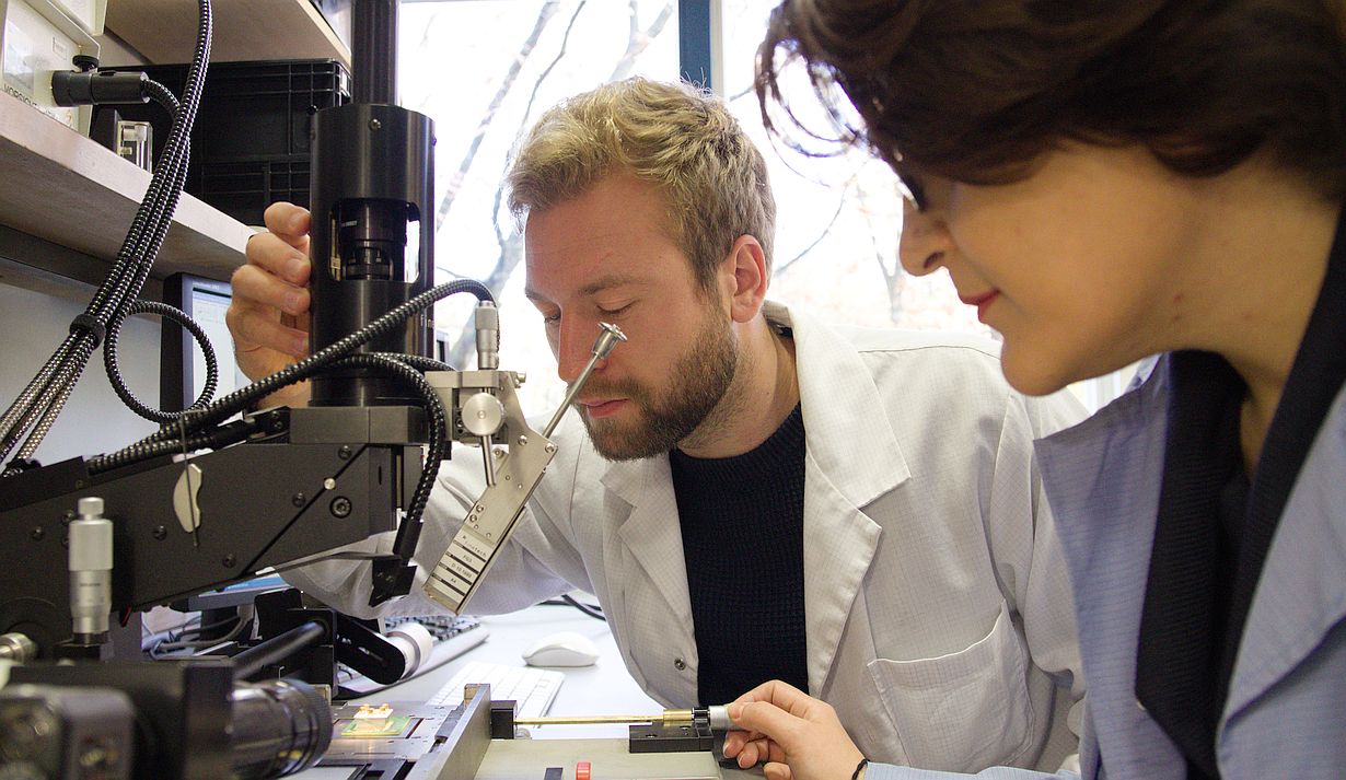  Sevda Abadpour und Axel Diewald vom Institut für Hochfrequenztechnik und Elektronik (IHE) des KIT positionieren einen Chip auf einer Platine. Gerade bei einer Größe im Mikrometerbereich muss alles perfekt ausgerichtet sein. (Foto: Joachim Hebeler, KIT)