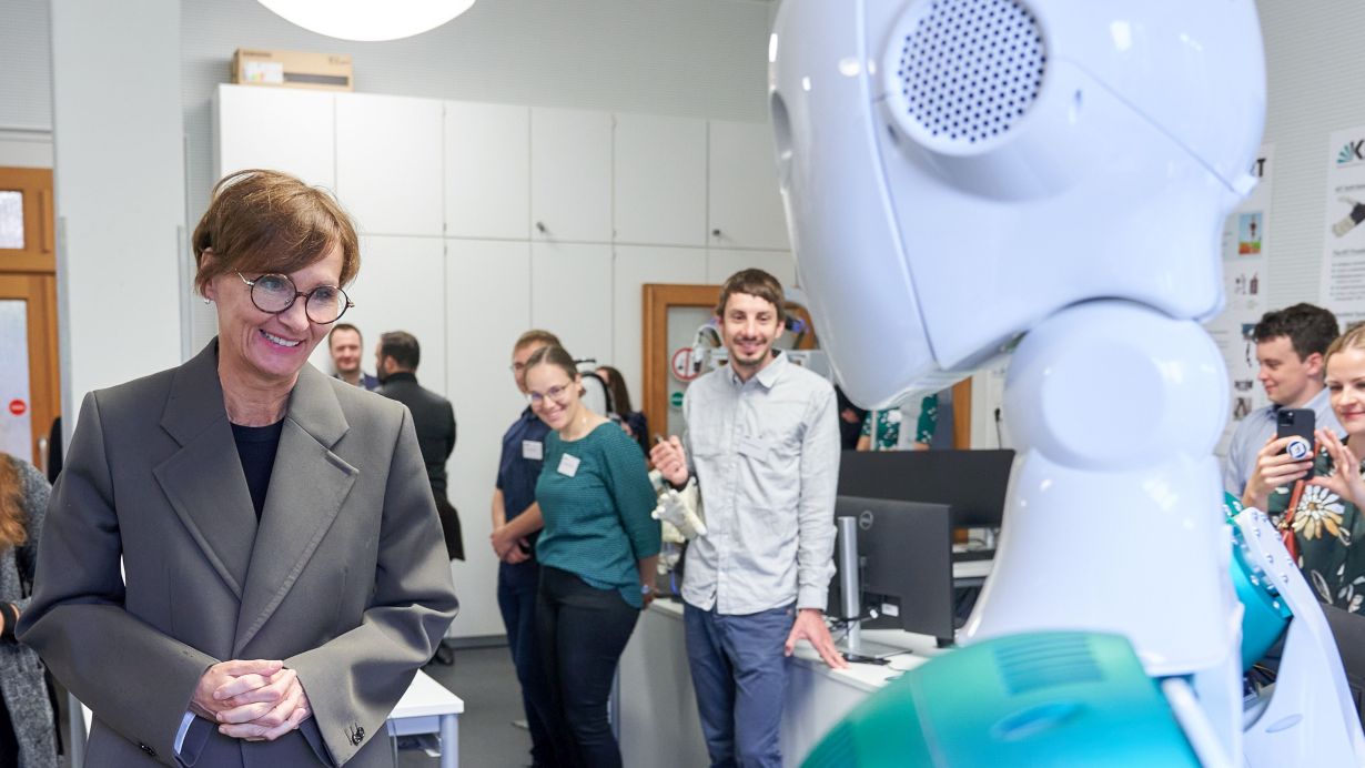 The humanoid ARMAR-6 robot developed by KIT welcomes Federal Research Minister Bettina Stark-Watzinger (left) at IAR. (Photo: Amadeus Bramsiepe, KIT) 