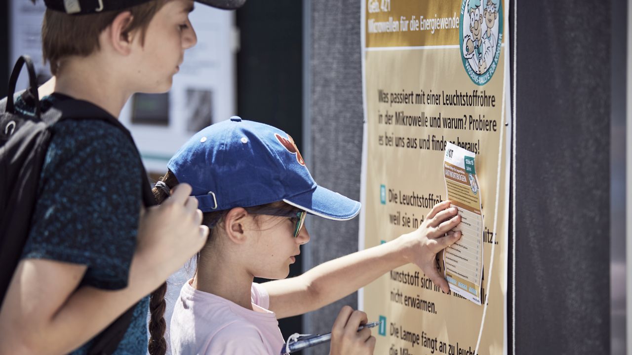 Ein Kind füllt an einer Station der Wissensrallye einen Fragebogen aus