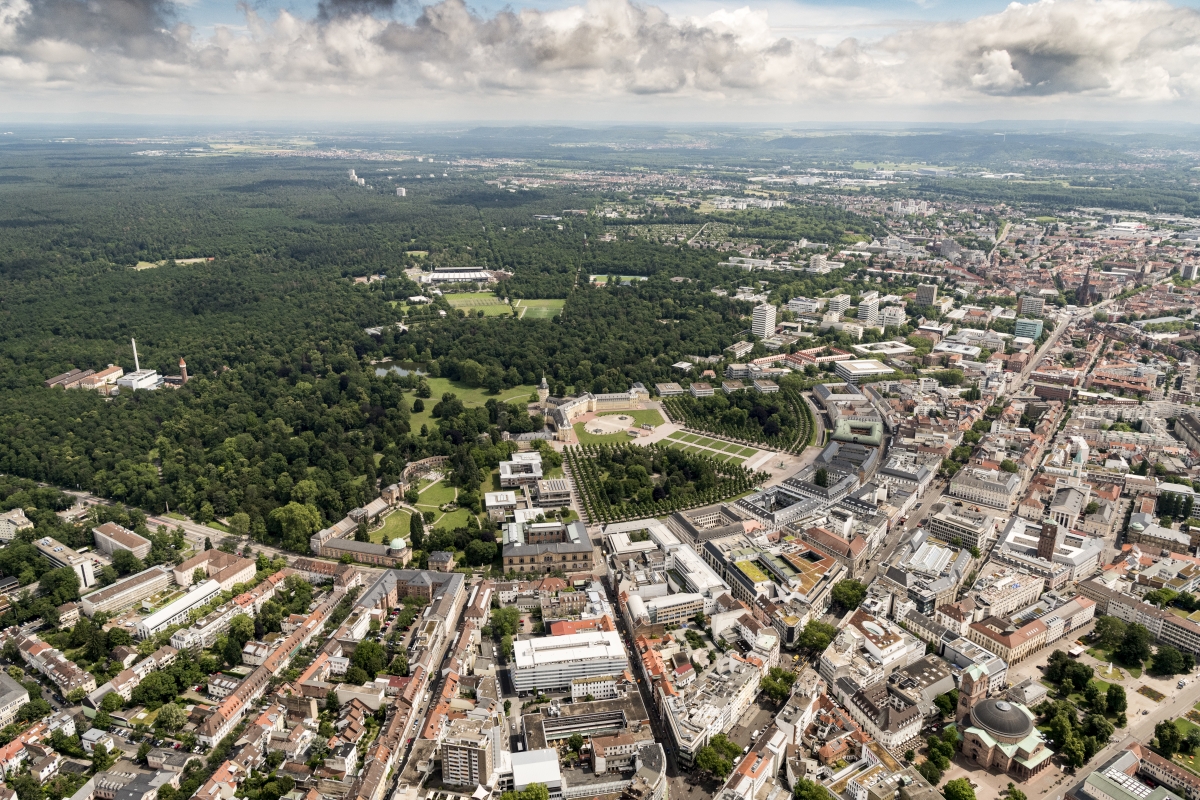 Luftbildaufnahme von Karlsruhe mit Blick auf das Schloss. Dahinter befindet sich der weitläufige Hardtwald.
